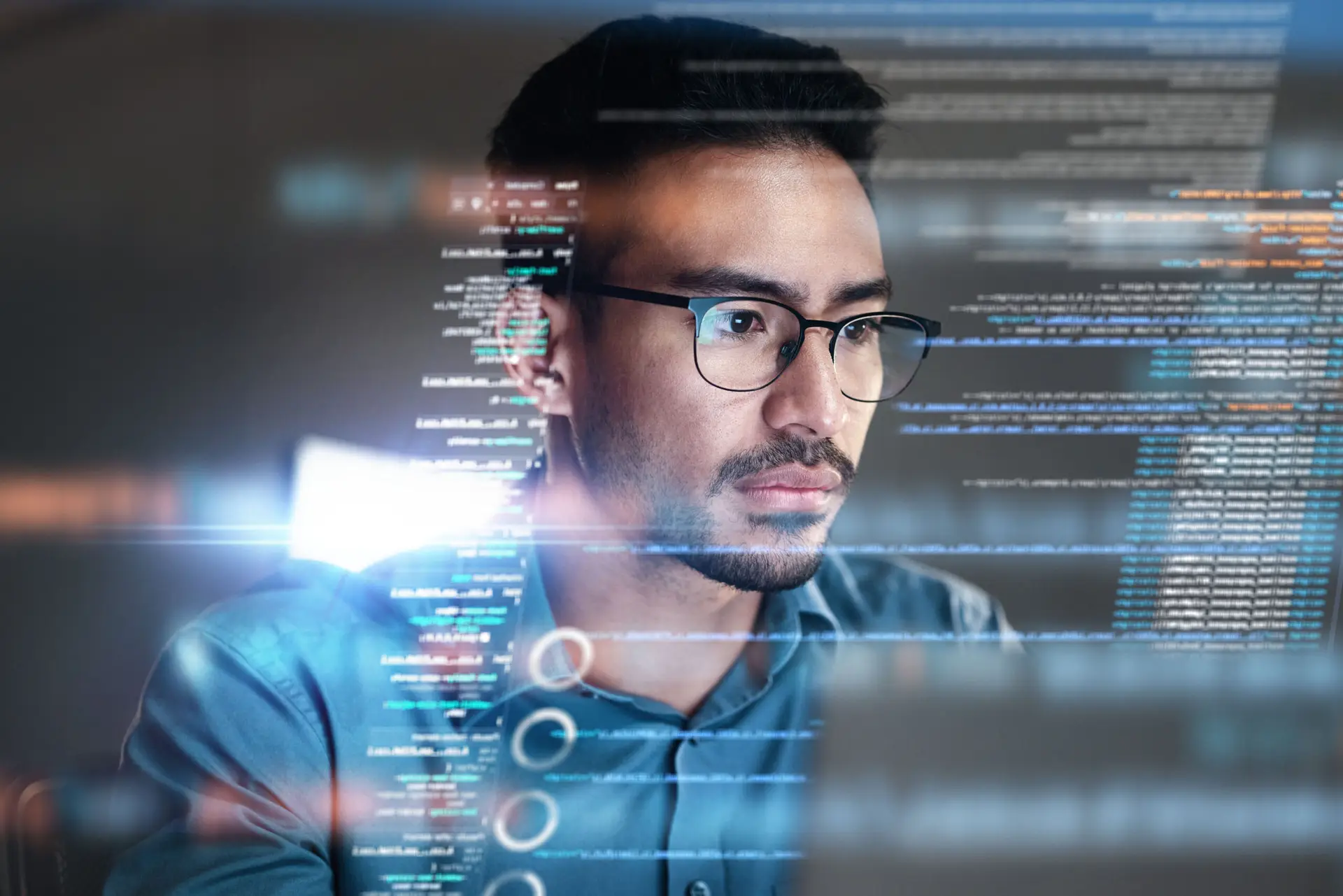 Man with holographic programming code focusing on cyber security and data analytics
