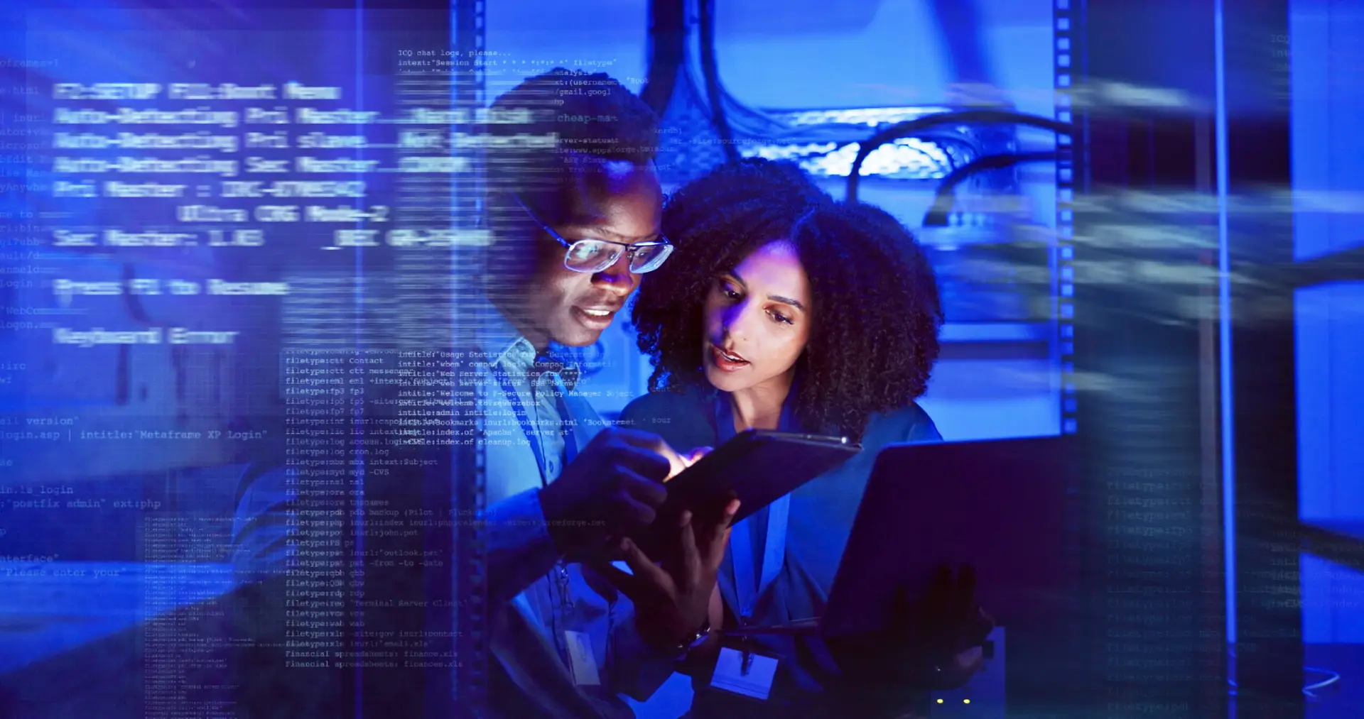 Two IT professionals looking at a tablet and laptop in a blue-lit server room, with semi-transparent computer code overlaid across the image.